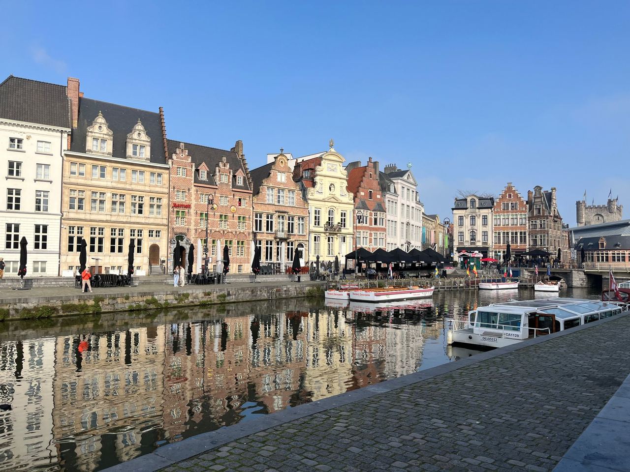 Historische gevels aan de Graslei in Gent, weerspiegeld in het water van de Leie
